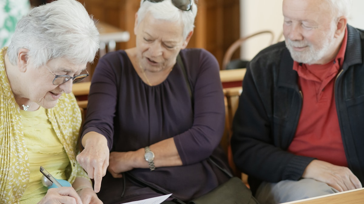 Trois personnes seniors examinant ensemble un document