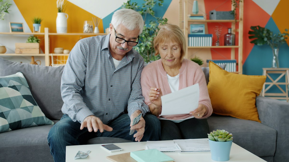 Couple de retraités examinant ensemble un courrier et leurs documents de pension