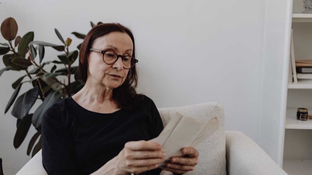 Femme lisant un courrier officiel concernant sa pension de réversion
